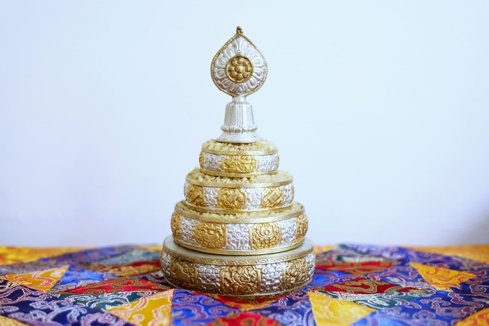 A mandala offering set filled with rice.